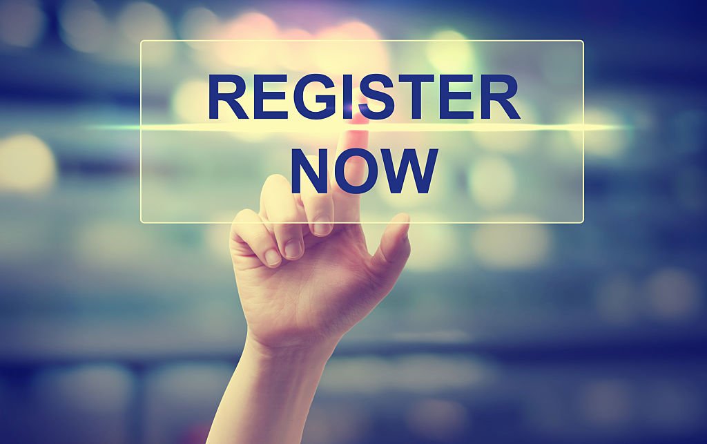 hand pressing register now on blurred cityscape background